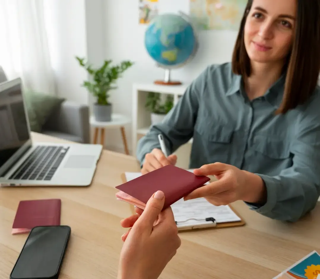 A consultant handing a passport back to a client across a desk